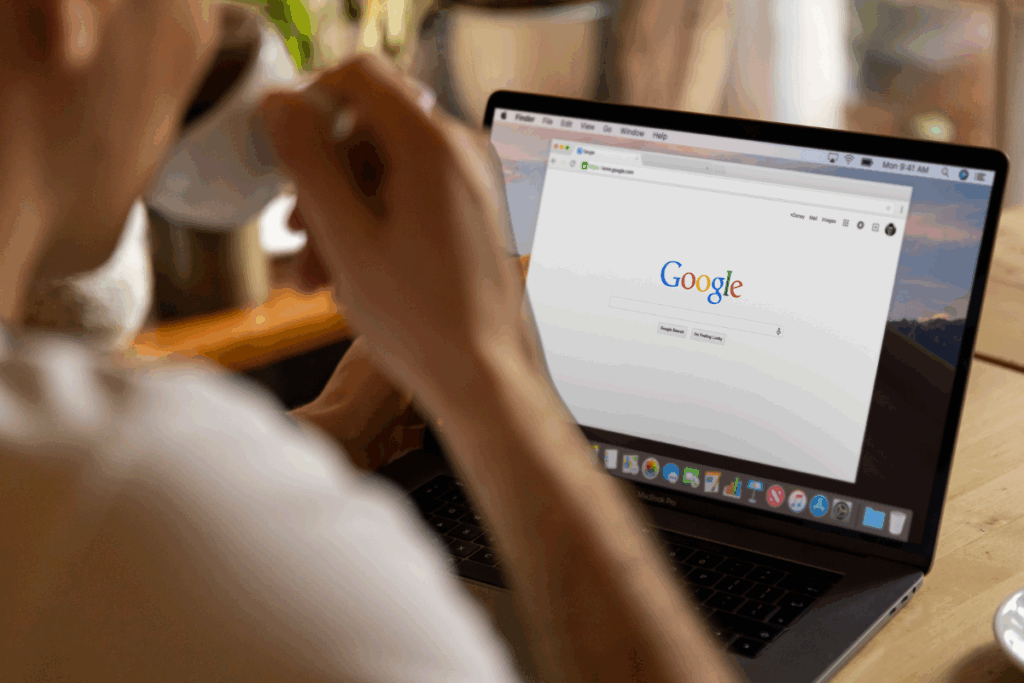 A person sat in front of a Laptop with Google open: 7 SEO tips for how to optimise for AI overviews